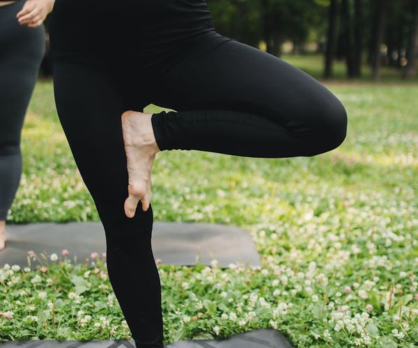 Relaxed person standing in a balanced yoga pose outdoors